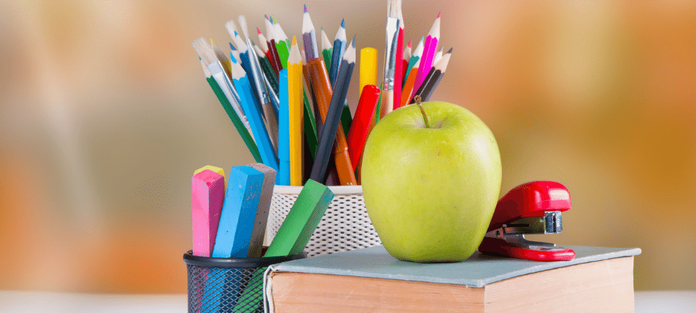 school supplies and apple on a book