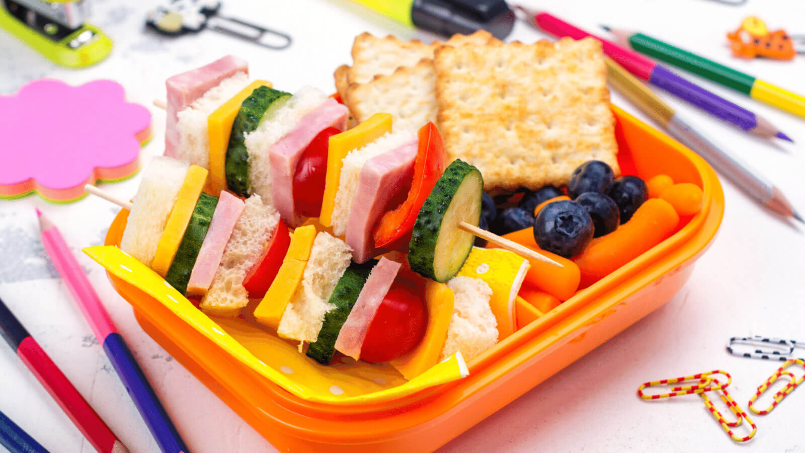 Open lunchbox with school supplies.