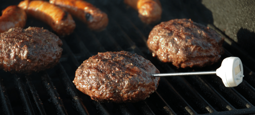 grilling hamburgers and hot dogs with food thermometer