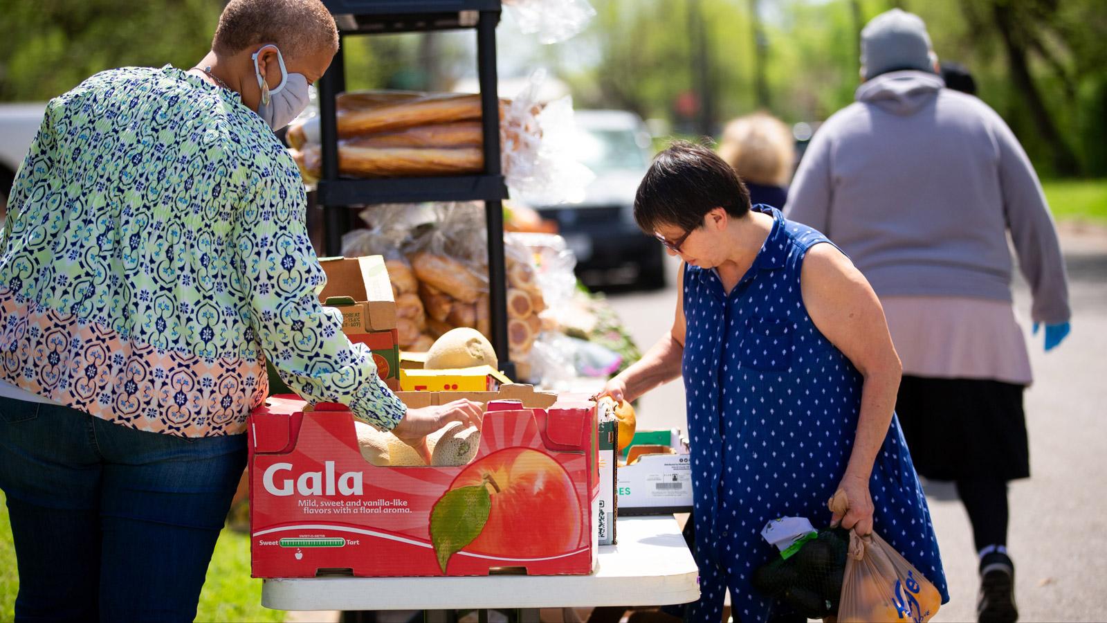 Women picking out fruit at a food pantry.