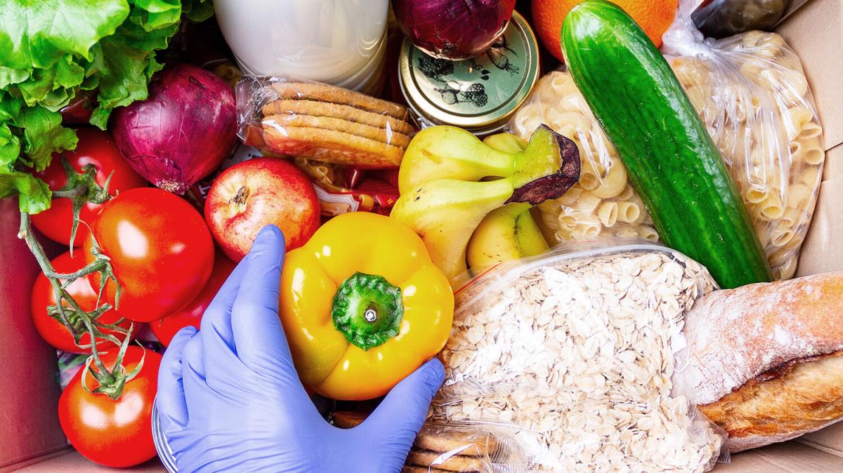 person preparing a box of food donations.