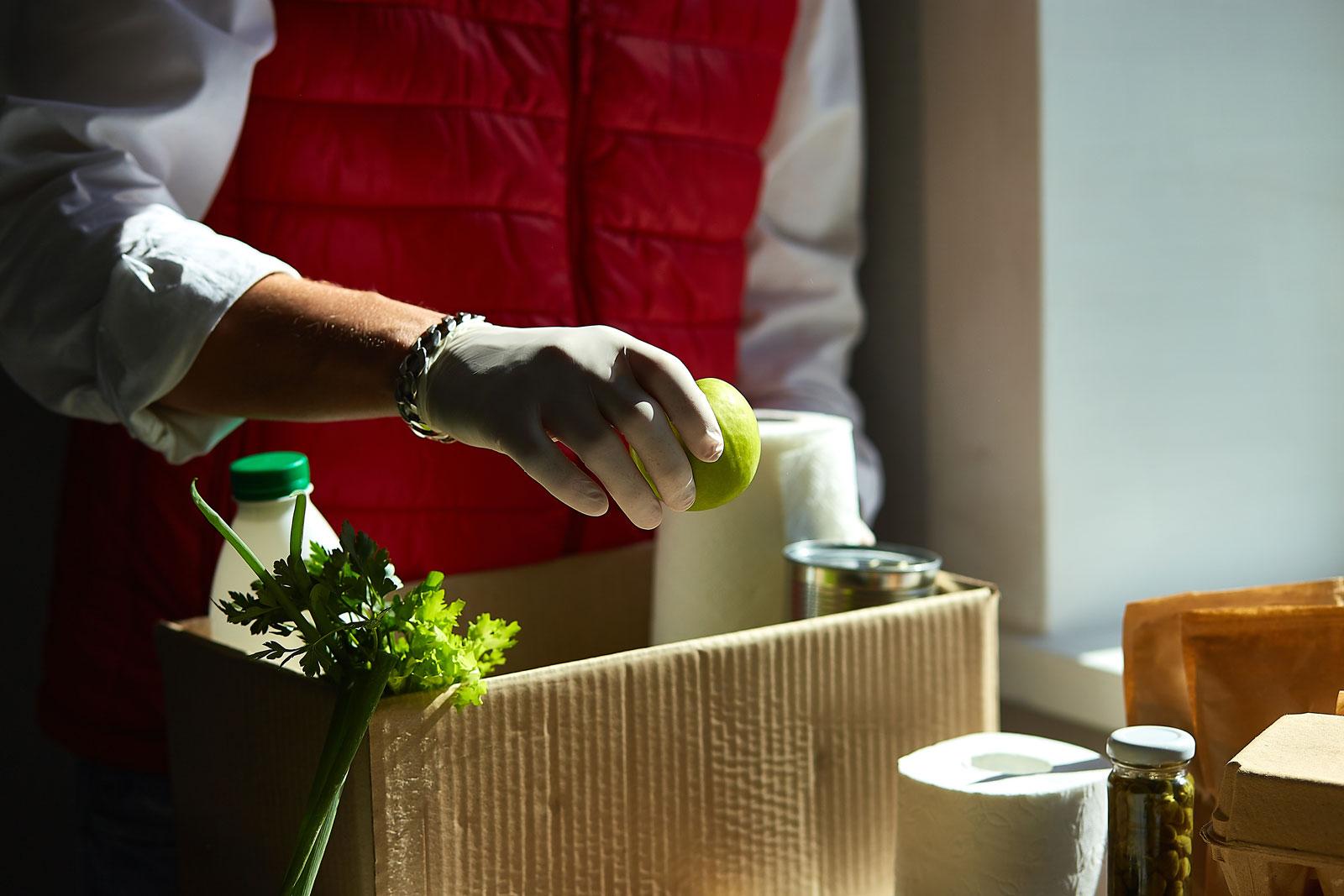 Person putting food into a box.