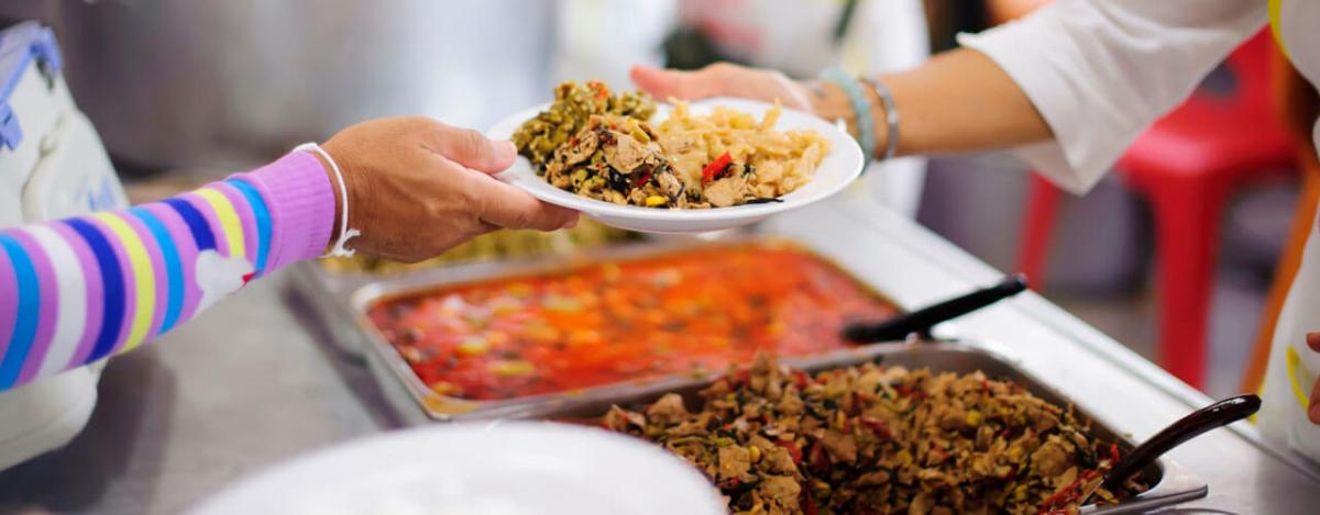 Person moving through a buffet line.