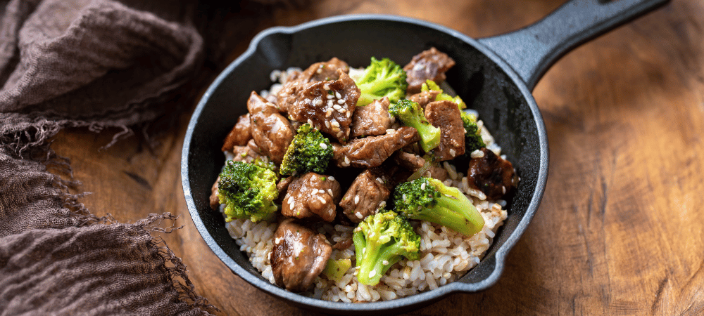 beef broccoli with rice in a skillet