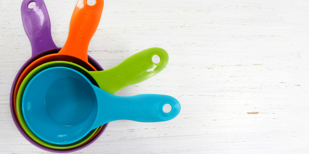 baking background with bright colored measuring cups