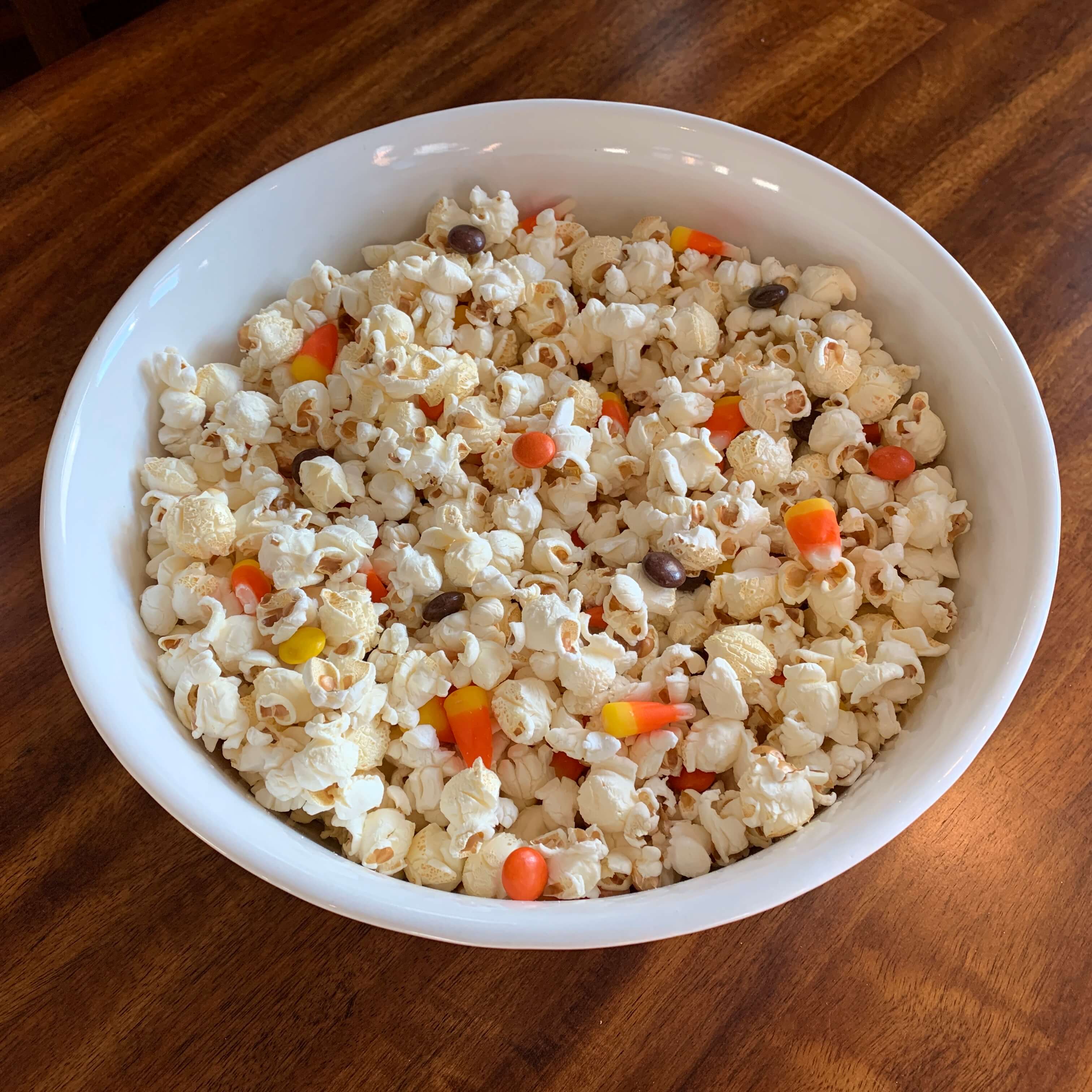 popcorn mixed with candy corn and orange, brown, and yellow candy pieces filled with peanut butter