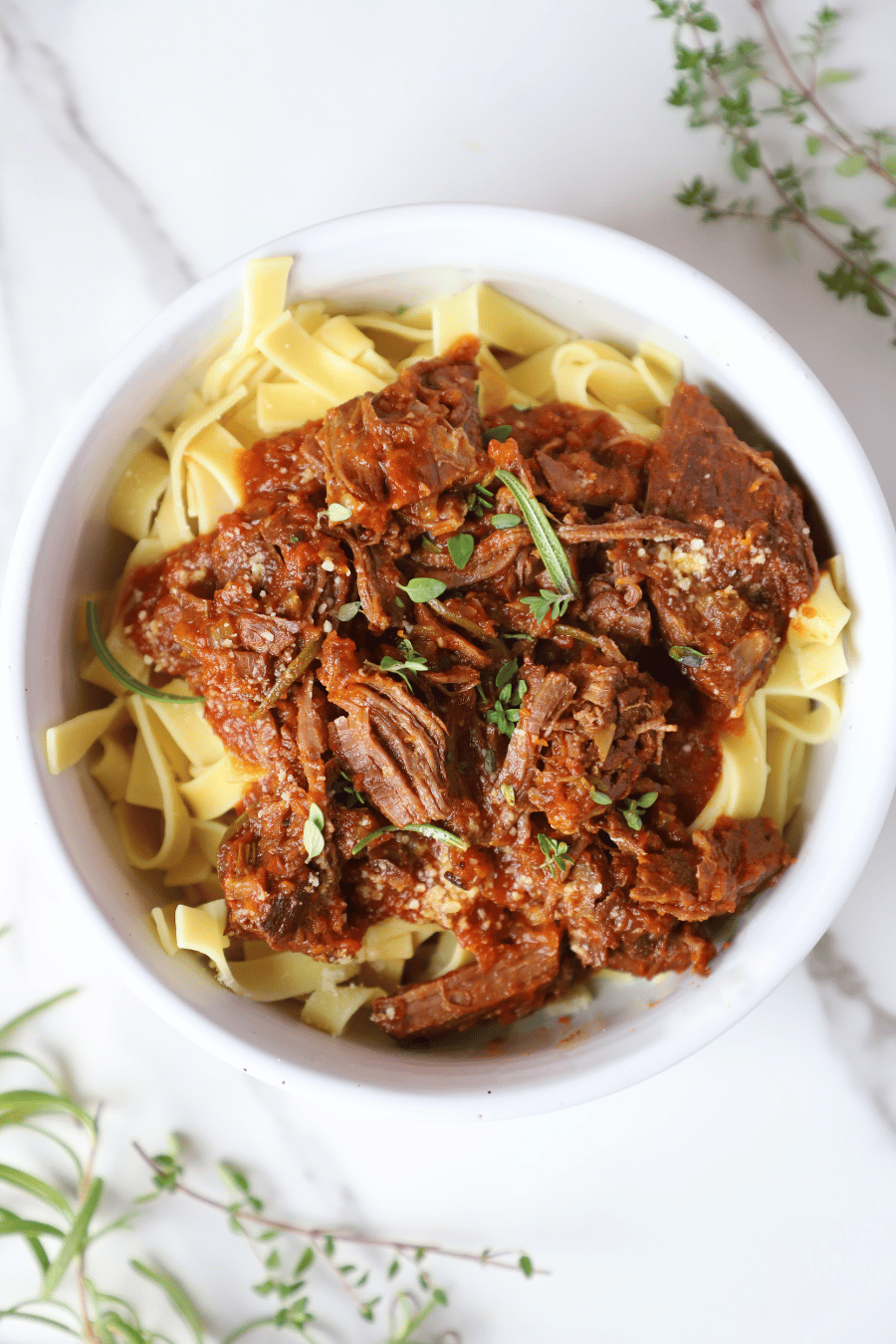 A bowl of beef ragu over noodles