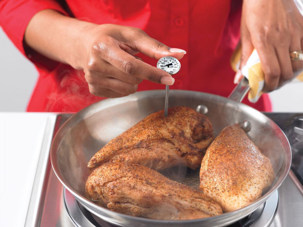 Woman testing the temperature of chicken