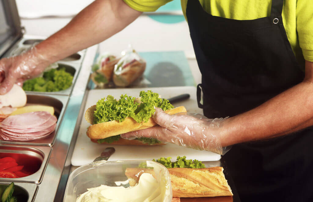 Food service employee making a sandwich