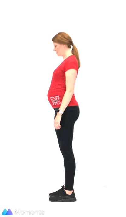 A pregnant women modeling how to do a calf raise exercise.
