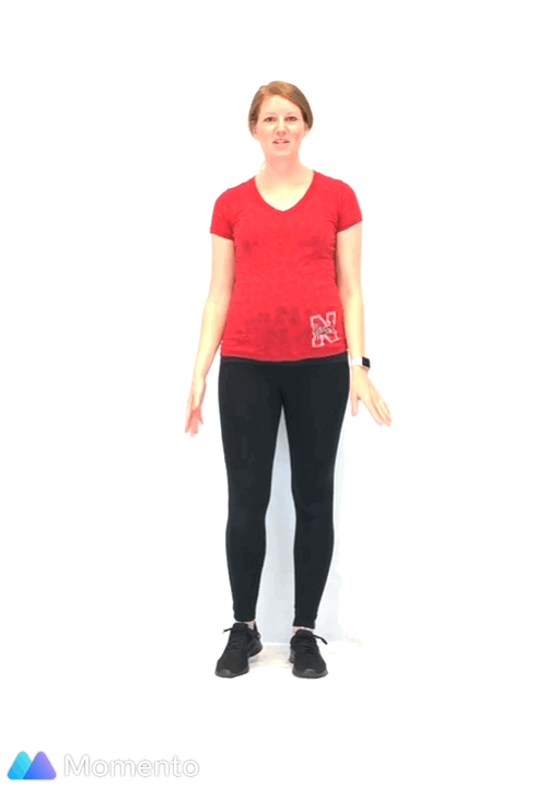 An individual modeling how to do a low impact jumping jack exercise.