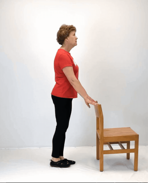 An individual modeling how to do a back leg raise exercise.