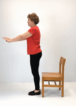 An individual modeling how to do an unsupported chair sit exercise.