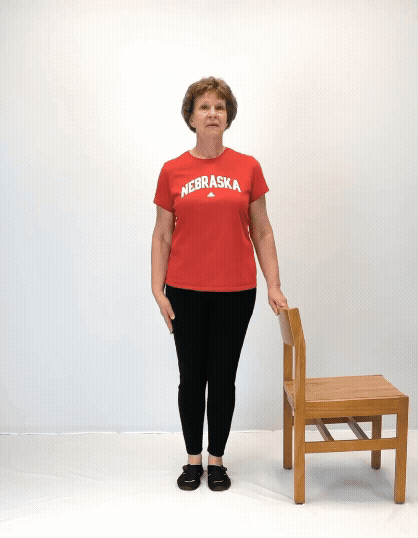An individual modeling how to do a side leg raise exercise.