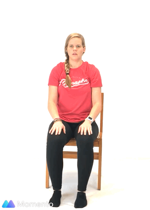 An individual modeling how to do a modified eagle yoga pose.