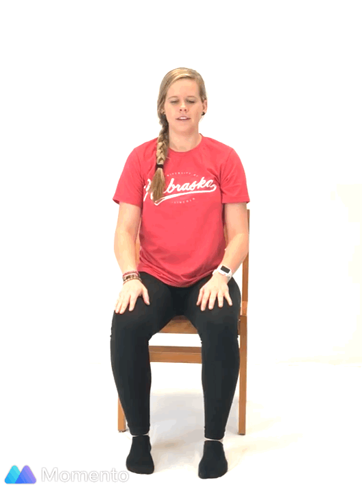 An individual modeling how to do a modified pigeon yoga pose.