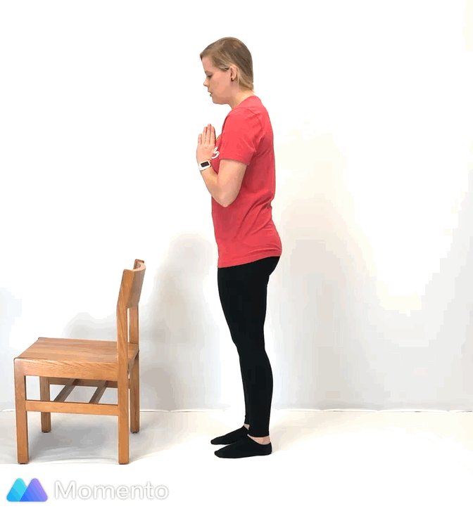 An individual modeling how to do a modified warrior III yoga pose.