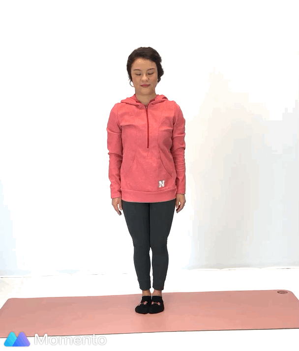 An individual modeling how to do an eagle yoga pose.
