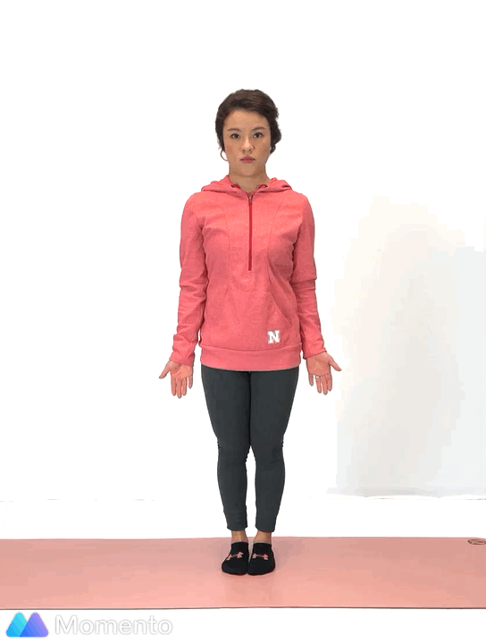 An individual modeling how to do a tree yoga pose.
