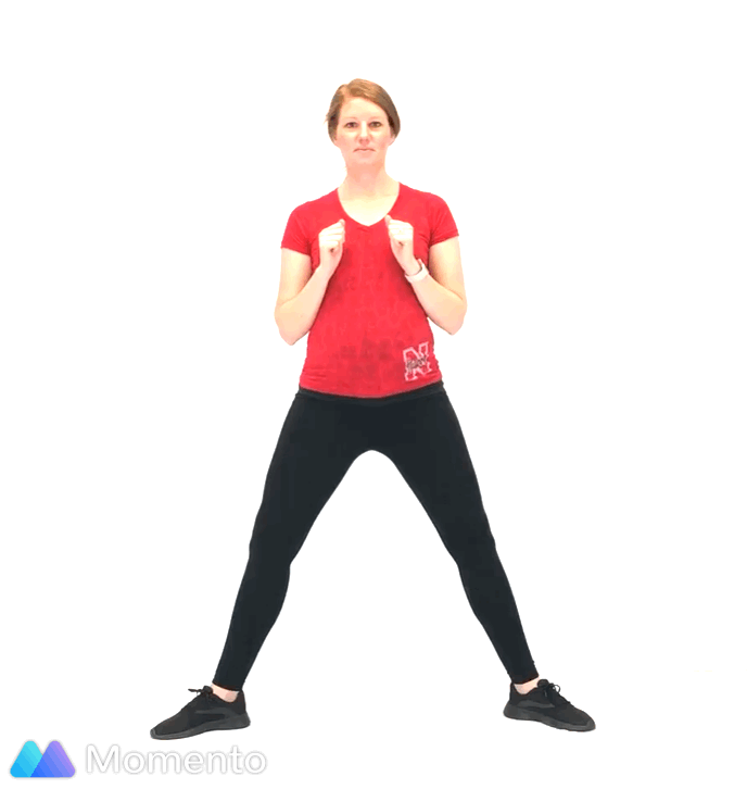 A pregnant women modeling how to do a sumo squat exercise.
