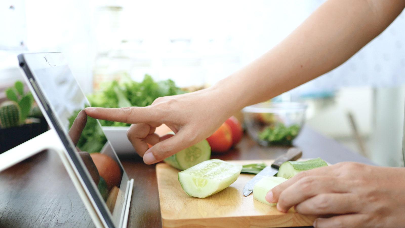 Person using an iPad in the kitchen.