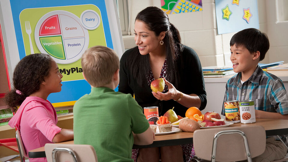 Educator teaching children about healthy foods.