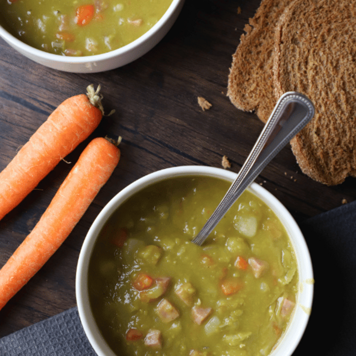 Split pea soup in a bowl with whole wheat bread on the side