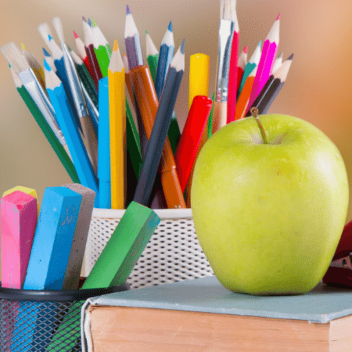 school supplies and apple on a book