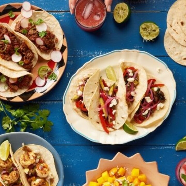 table of food with tortillas, corn, salsa