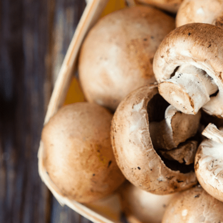 mushrooms in a basket on a wood table