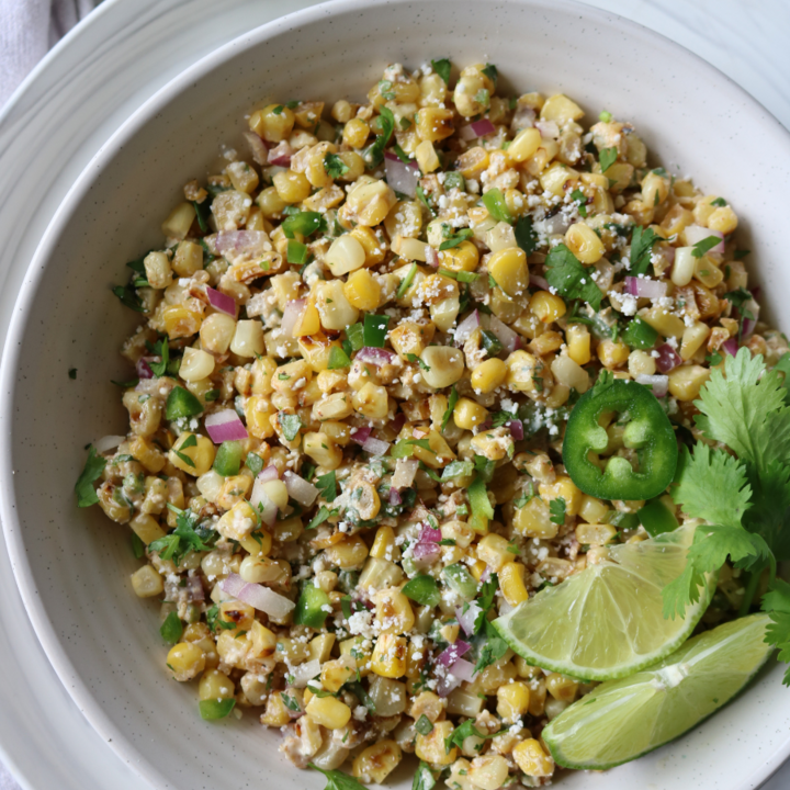 Elote salad in a bowl with lime and cilantro