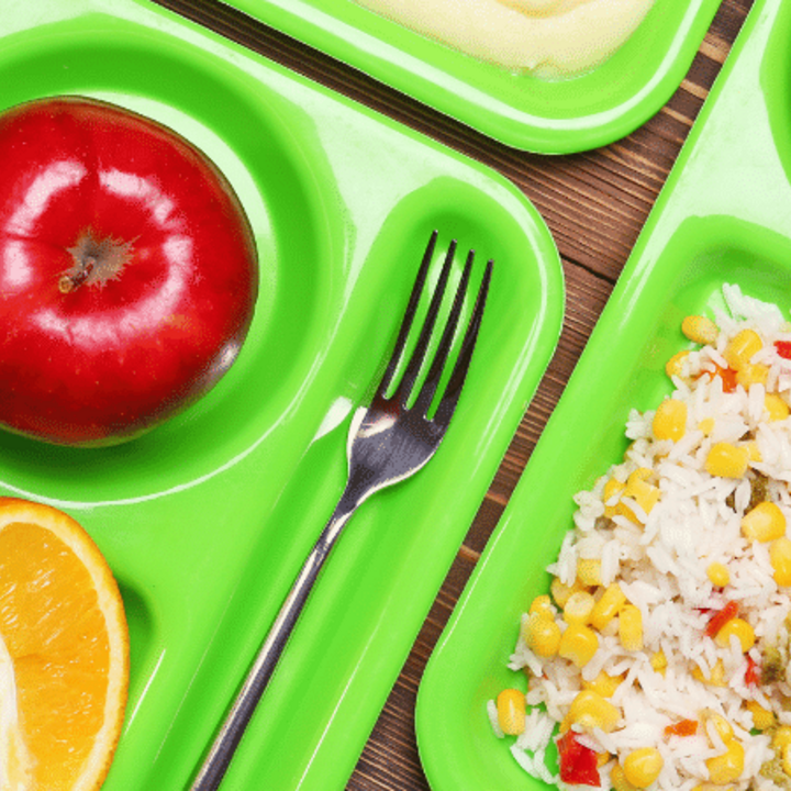 school lunch trays with fresh produce on table