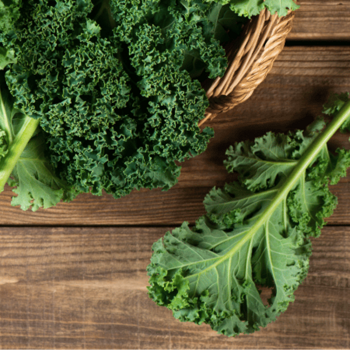 raw kale leaves on a wooden table