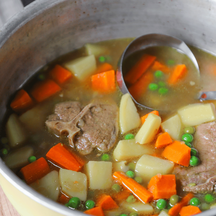 Soup in a pot with lamb, carrots, potatoes and peas