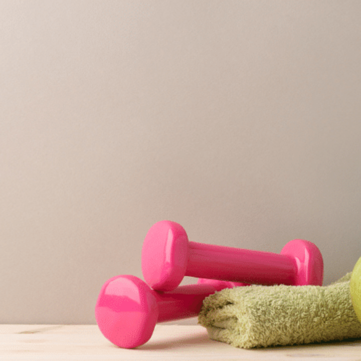 small dumbbells with apple, water bottle, and towel