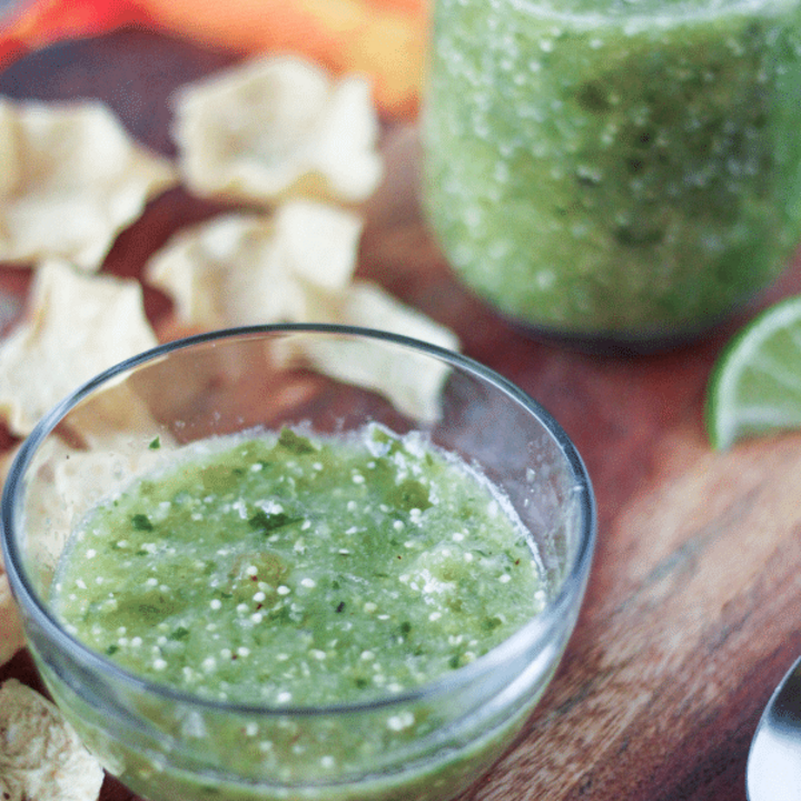 Tomatillo salsa in a cup and mason jar with tortilla chips