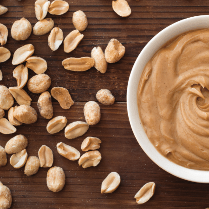 peanuts and peanut butter in a bowl on a table