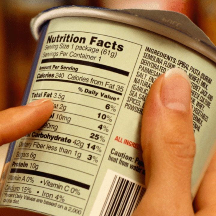 person reading a nutrition facts label on a food item