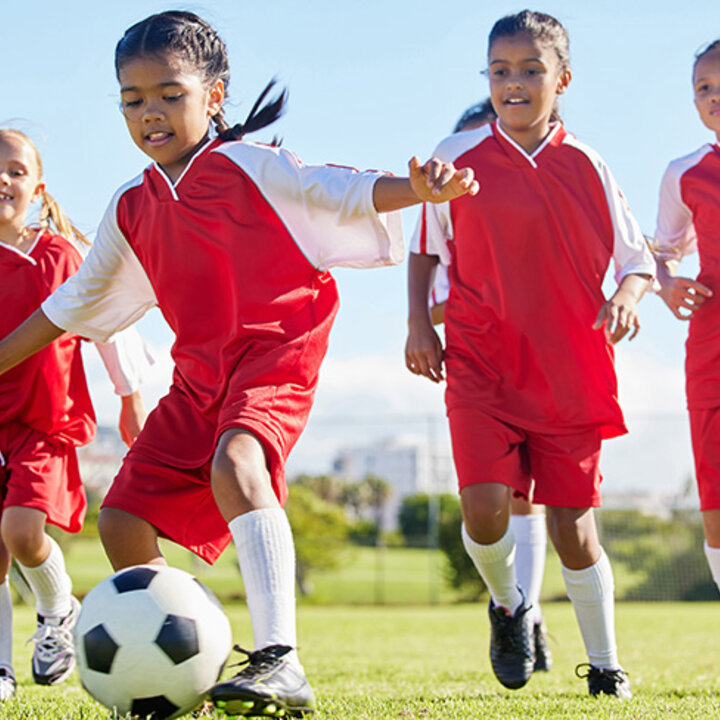 kids playing soccer with red uniforms