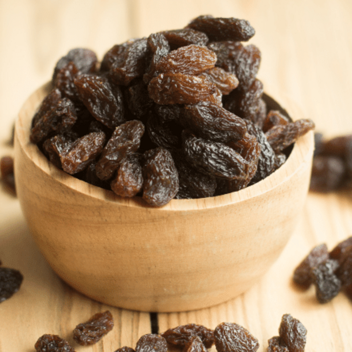 raisins in a wooden bowl on a table