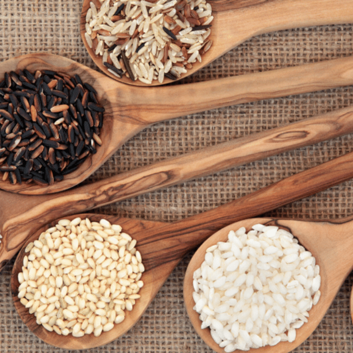 Rice varieties in olive wood spoons.