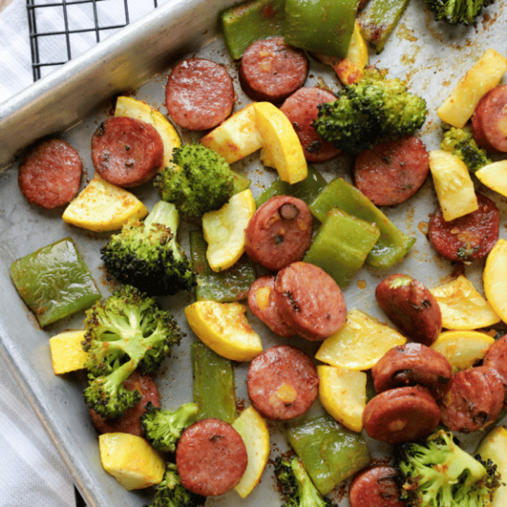 Sausage, bell peppers, summer squash and broccoli on a sheet pan