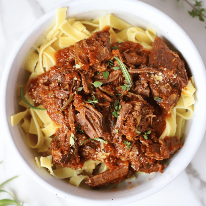 A bowl of beef ragu over noodles