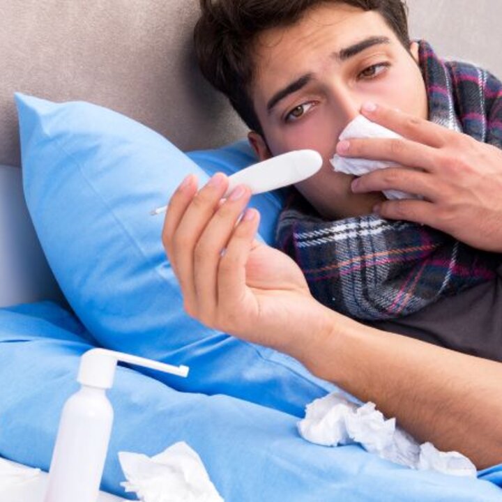 sick person with thermometer and tissues