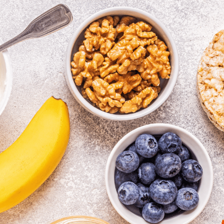 healthy snacks such as yogurt, banana, blueberries, walnuts, and rice cakes