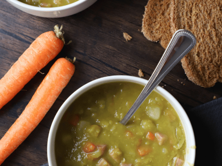 Split pea soup in a bowl with whole wheat bread on the side