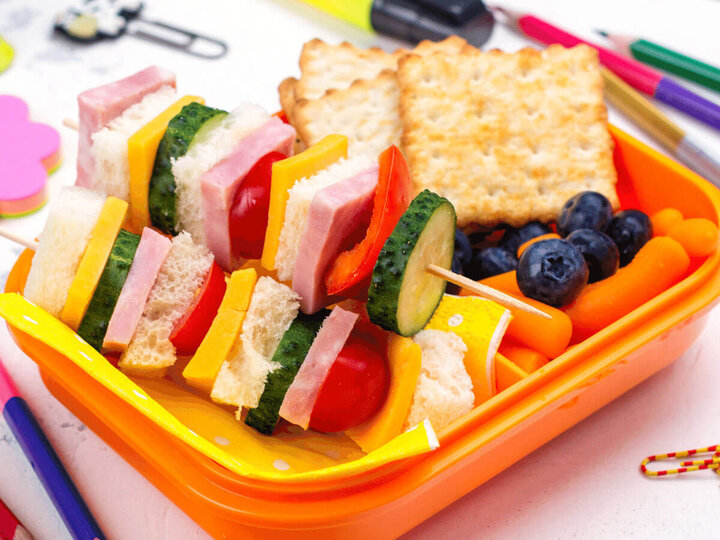 Open lunchbox with school supplies.