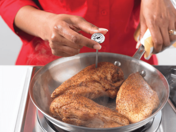 using a food thermometer to check the temperature of the chicken