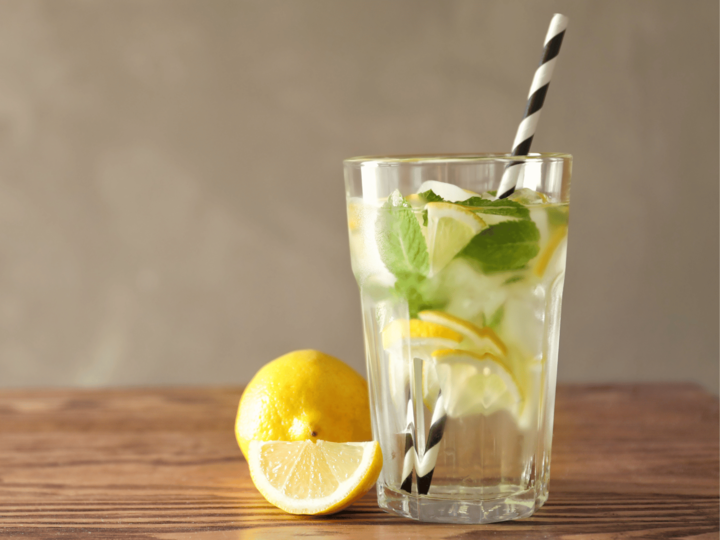 glass of water with lemon on a wood table