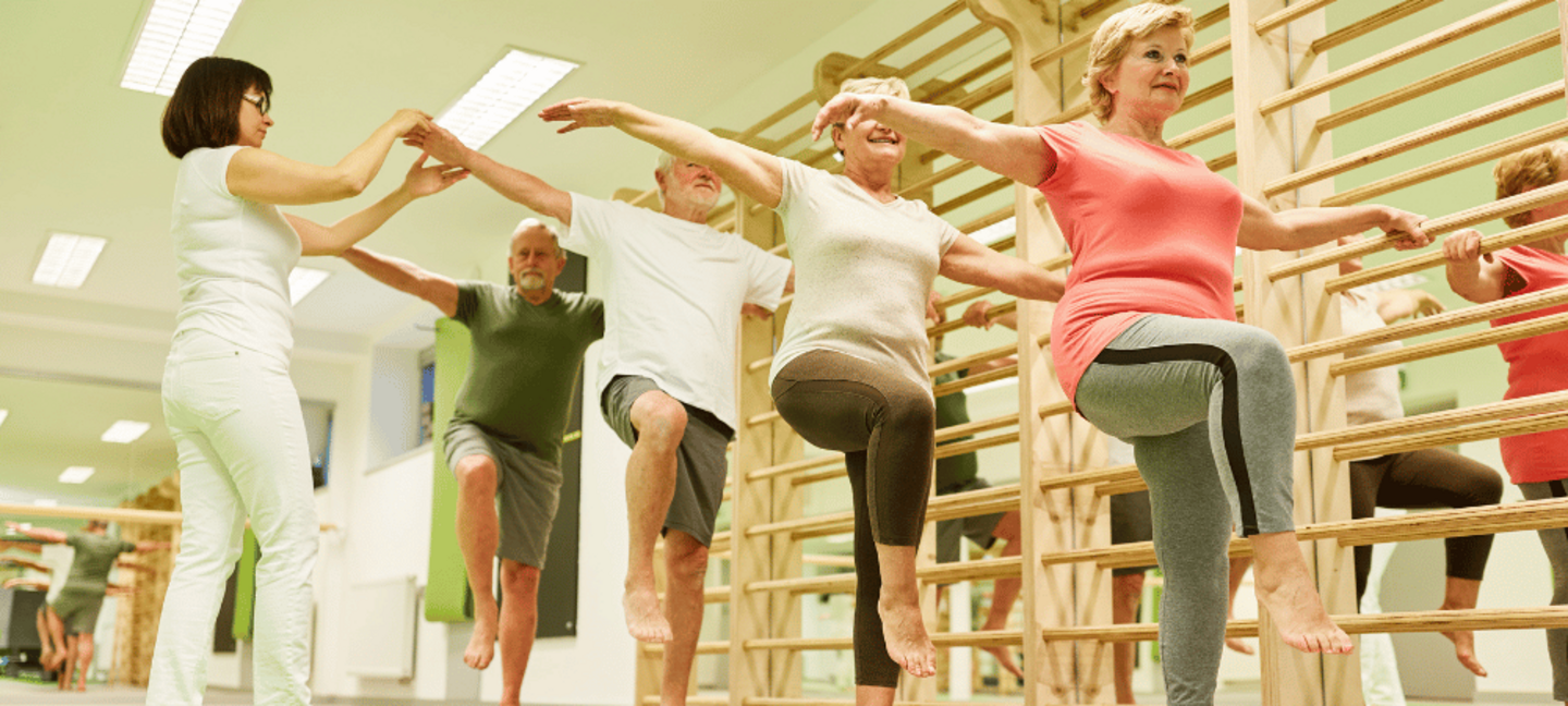 group of seniors doing balance exercise on one leg